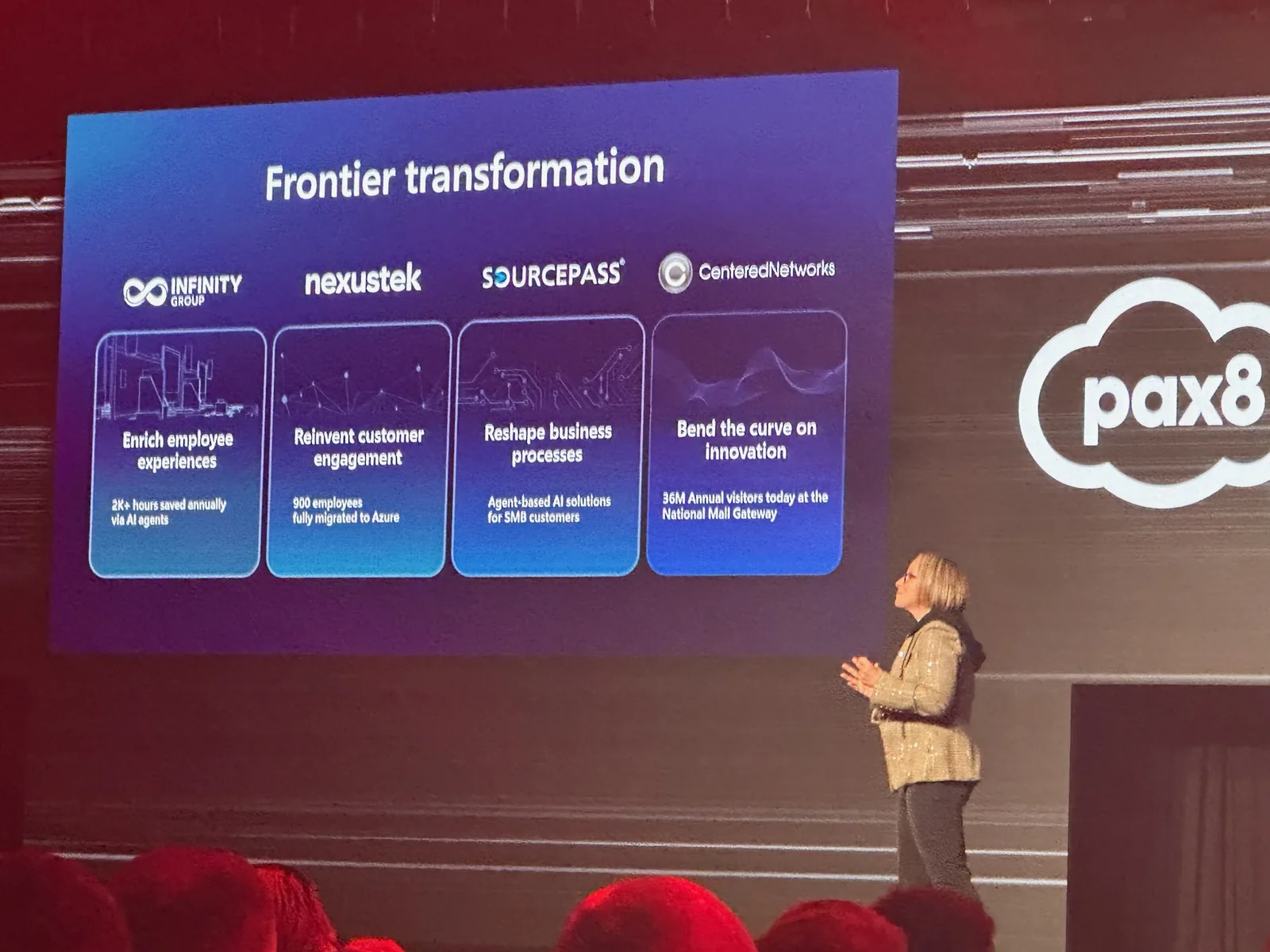 Nicole Dezen, Microsoft's Chief Partner Officer, on the main stage at Pax8 Beyond 2026 beside the Frontier transformation slide, with the illuminated pax8 cloud logo on the wall.